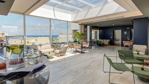 A spacious rooftop lounge with a glass ceiling, modern furniture, and a view of the city. - Number 11 St Julian's Malta - Handwritten Collection (St. Julian's)