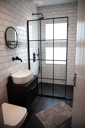 Apartamento grand | Banheiro | Chuveiro, chuveiro com efeito de chuva, secador de cabelo 