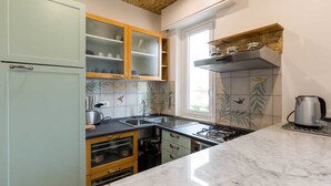 A kitchen with a gas stove, a sink, and a window. - Solemar Sicilia - Casa Colibrì (Santa Flavia)