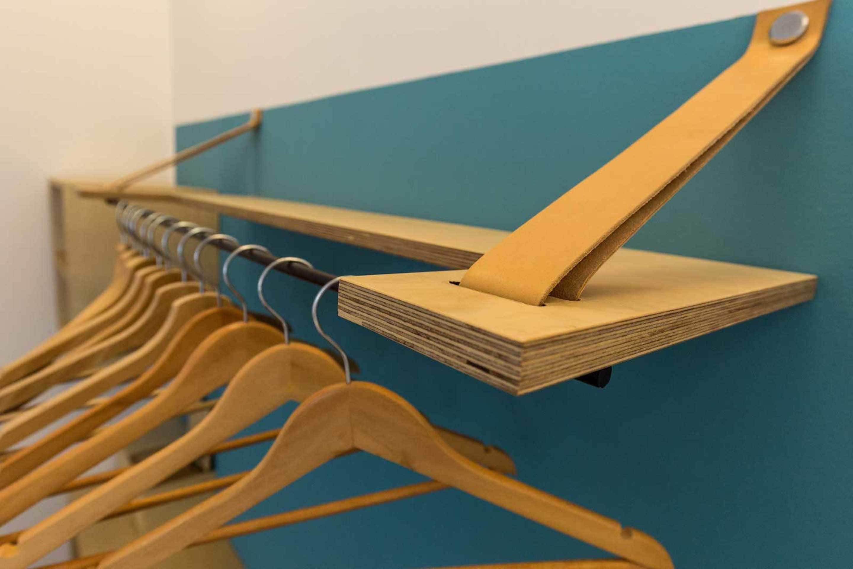 Un perchero de madera frente a una pared azul.