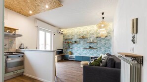 A modern kitchen with a built-in oven and a dining area with a wooden table. - Solemar Sicilia - Casa Colibrì (Santa Flavia)