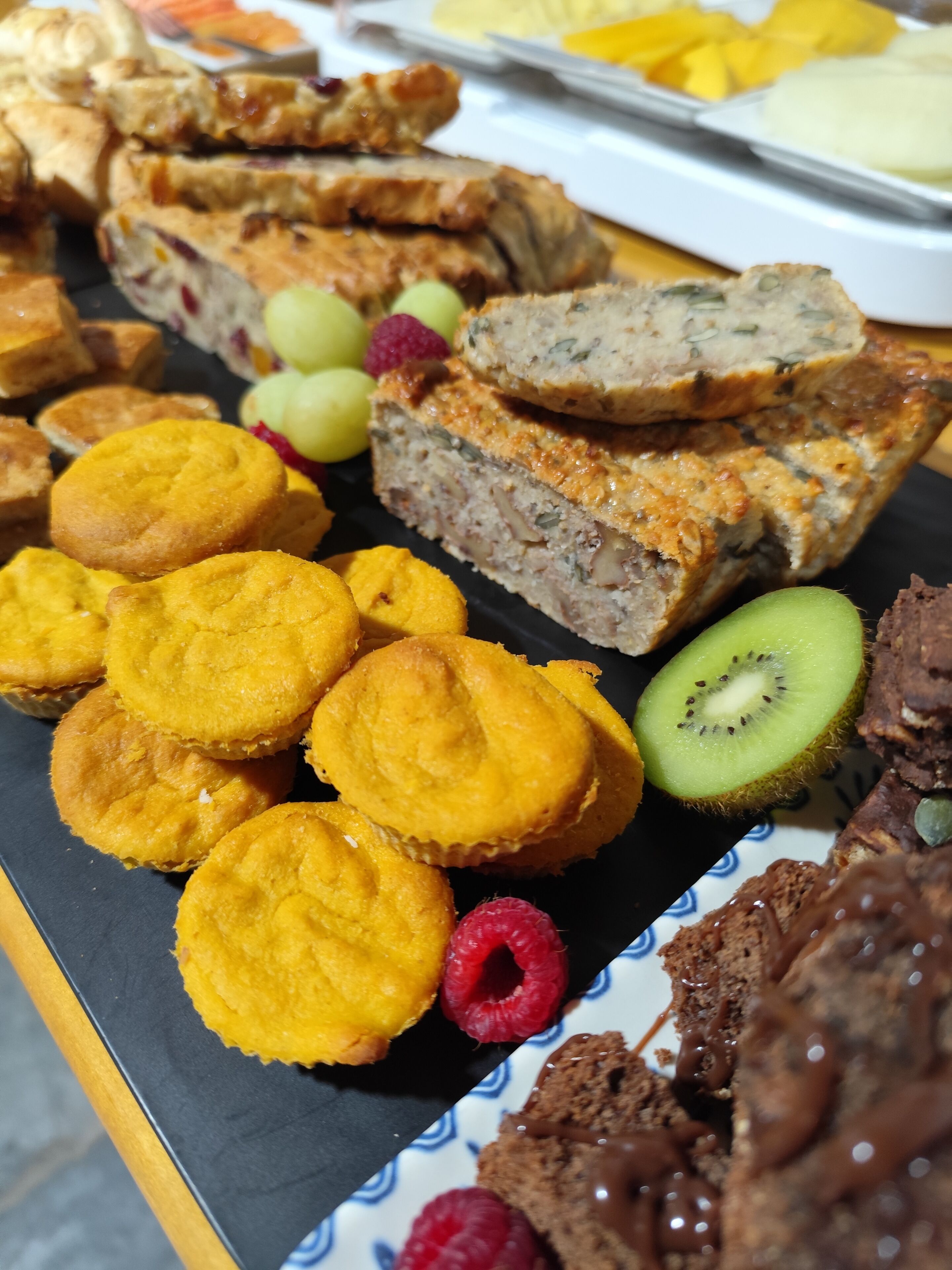 Un assortiment de produits de boulangerie, notamment des muffins, une miche de pain et un dessert au chocolat.