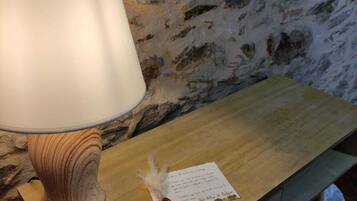 Un escritorio de madera con una lámpara, un adorno pequeño y un papel con texto.