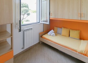 A compact room with a bed, a window, and a radiator. - Solemar Sicilia - Villa Sicilia (Lascari)