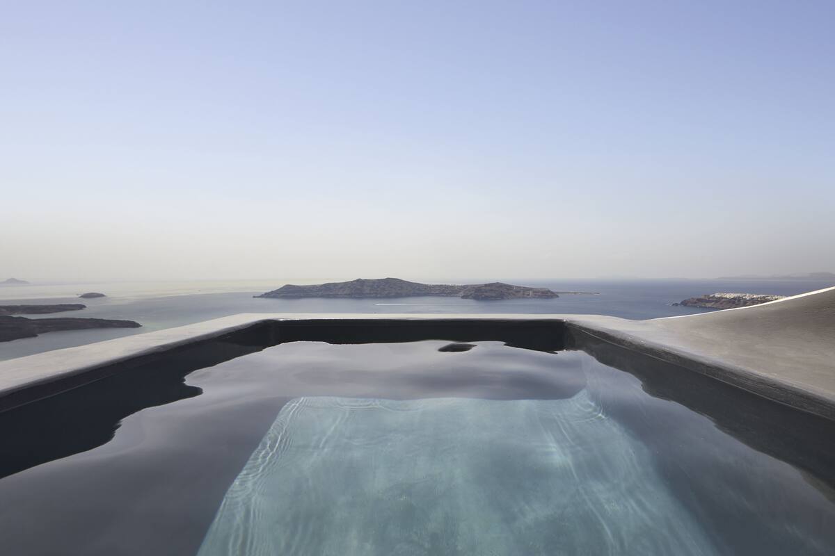 A clear view of a swimming pool with a view of the sea and distant islands.