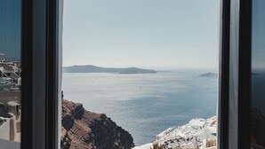 Vista costera con edificios blancos, cielo despejado y el mar.