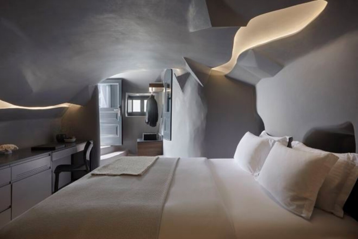 Une chambre moderne avec un grand lit, un bureau et une chaise.