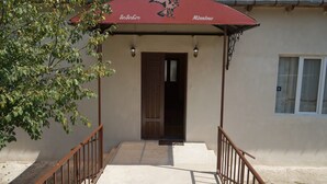 A building entrance with a red awning displaying the names "Andromeda" and "Mimino". - Mimino (Kutaisi)
