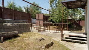A fenced outdoor area with concrete steps leading up to a building. - Mimino (Kutaisi)