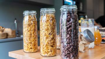 Three glass jars containing different food items on a wooden table.