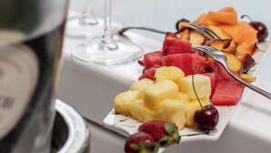 Una bandeja de frutas variadas y una botella de champán.