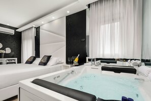 Una habitación de hotel moderna con dos camas, una bañera grande y un tocador con espejo.