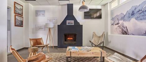 Una habitación acogedora con chimenea, muebles de madera y obras de arte en las paredes.