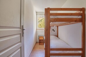 Ein Etagenbett in einem kleinen Zimmer mit Blick auf eine Landschaft.