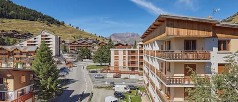Zona residencial con edificios de varios pisos, una avenida principal y una montaña al fondo.