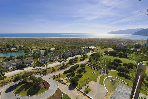 A residential area with houses, a roundabout, and a view of the sea.