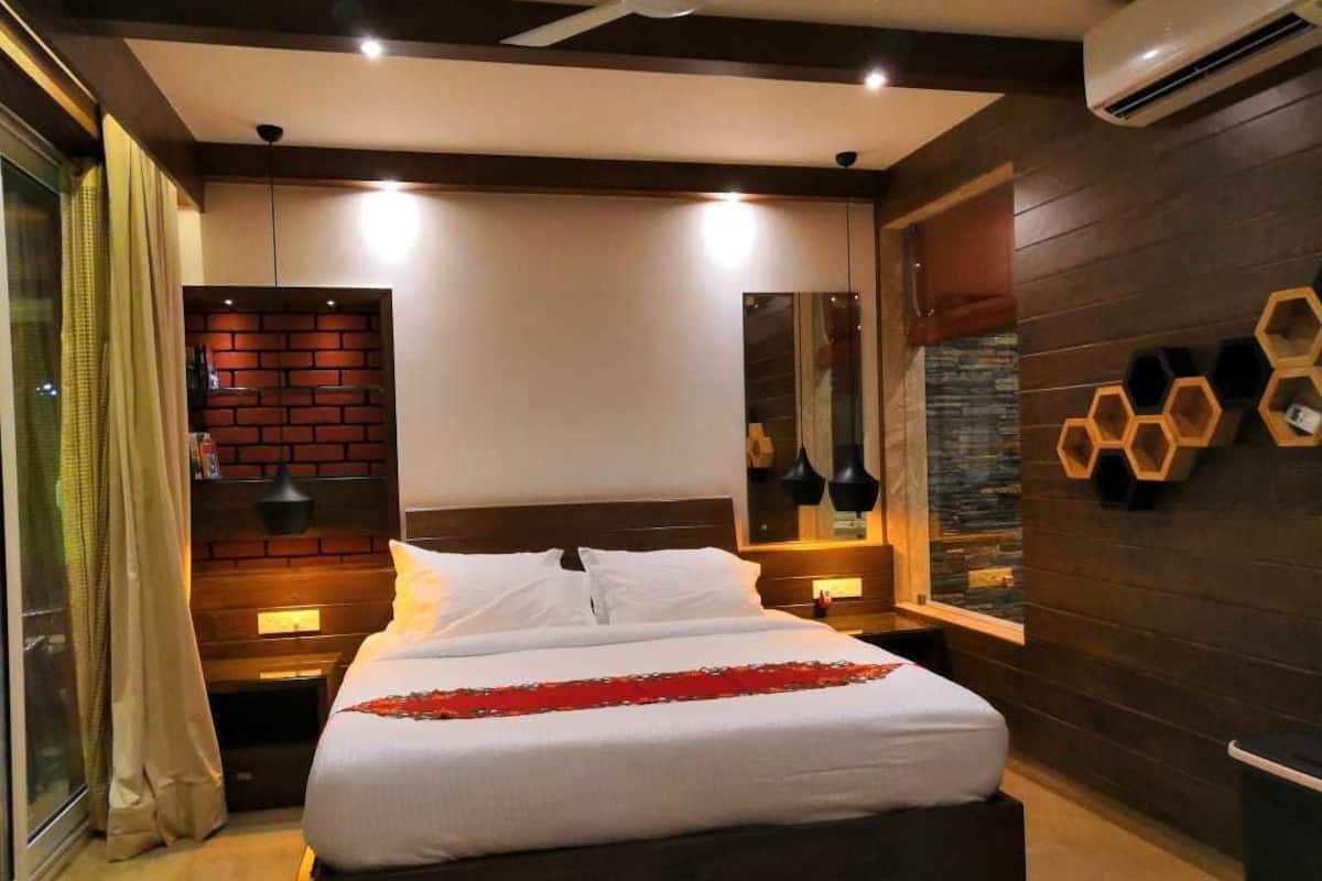 Un dormitorio moderno con una cama grande, detalles de madera y un diseño de pared de ladrillo.