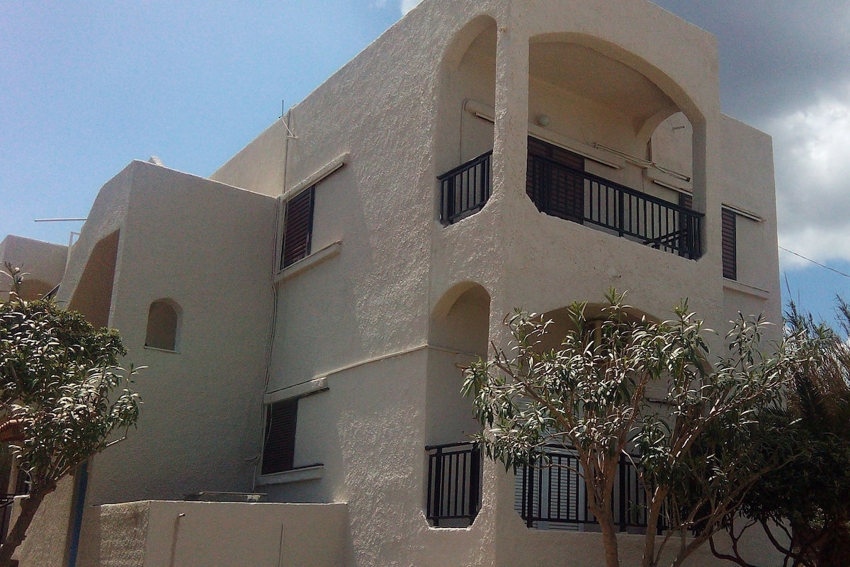 A multi-story building with balconies and arched windows.
