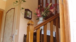 A wooden staircase with a vase of flowers on the landing. - Chambres d'hotes de la Ville Patouard (Tremereuc)