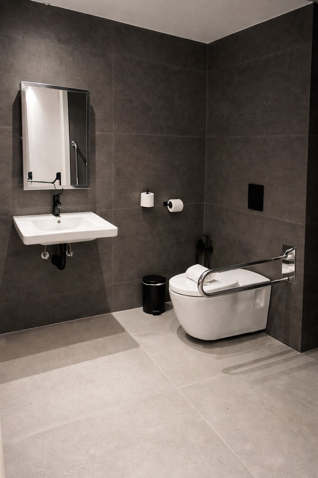 A modern bathroom with a white sink, mirror, and bathtub.