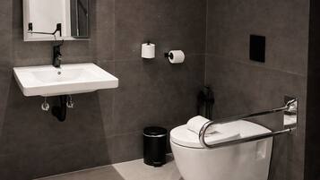 A modern bathroom with a white sink, mirror, and bathtub.
