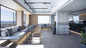 Un interior moderno con una amplia zona de comedor, asientos y una cocina.