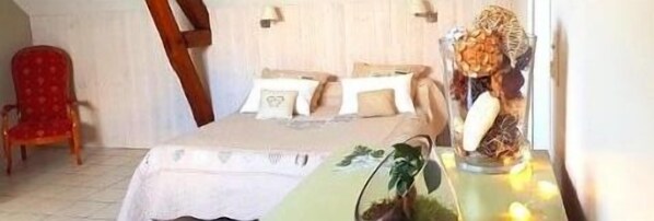 A bedroom with a bed, pillows, a chair, and a decorative vase with dried flowers. - Le Champ du Pre (Gievres)
