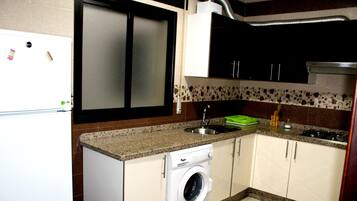 Comfort appartement | Privékeuken | Een koelkast met diepvriezer, een oven, een kookplaat, een waterkoker