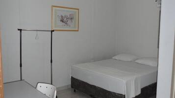 Ein kleines, sauberes Zimmer mit einem Einzelbett, einem Schreibtisch und einem Stuhl.