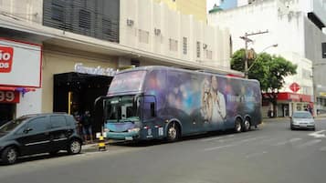 Un autobus est garé dans une rue de la ville, et il porte une grande publicité sur son côté.