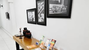 A reception desk with black and white framed photographs on the wall, a wooden counter, and black leather seating. - Grande Hotel Araçatuba (Aracatuba)