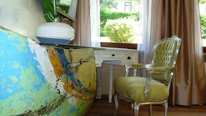 A room with a desk, a chair, a window with curtains, and a mirror on the wall. - Ferienwohnung Jeremy (Bad Toelz)