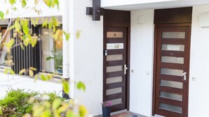 A house with two doors, a small porch, and a window. - Ferienwohnung Royal (Bad Toelz)