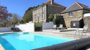 A swimming pool with a stone building in the background.
