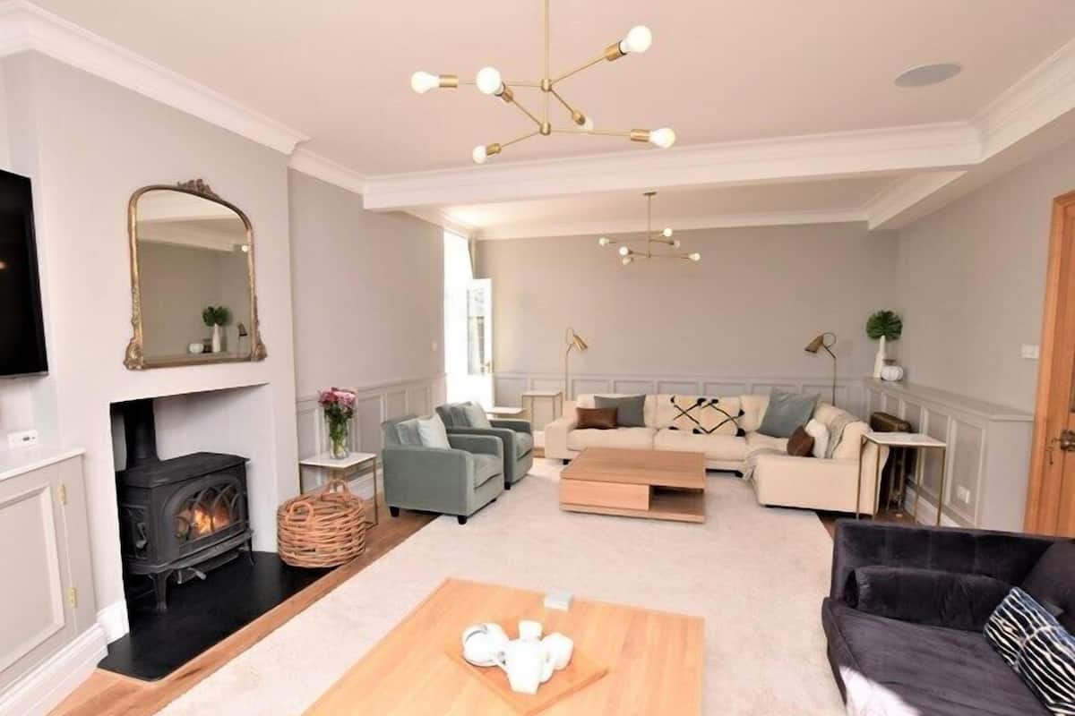 A living room with a fireplace, sofas, a coffee table, and a TV.