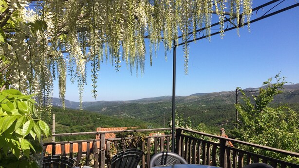 A terrace with a table and chairs, overlooking a mountainous landscape. - Beautiful renovated stone barn with magnificent view! Quiet village (Rabouillet)