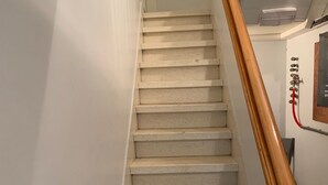 A staircase with a wooden handrail and a wall-mounted control panel. - Apartment Backhouse (Ostend)