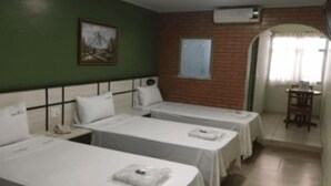 Une chambre d’hôtel avec deux lits simples, une petite table et une chaise.