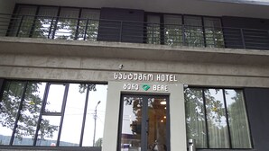 A hotel entrance with a sign reading "BERE HOTEL" and a green diamond symbol.