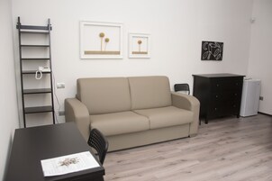 Habitación cuádruple | Zona de estar | Una televisión de pantalla plana