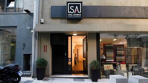 Un edificio con un cartel que dice "Still Athens Rooms & Apartments".