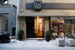 Un edificio con un cartello che riporta la scritta "Still Athens Rooms & Apartments".