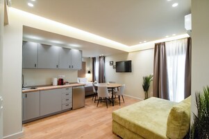 Un appartamento moderno con cucina, zona pranzo e soggiorno.