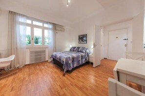 A bedroom with a bed, a chair, a desk, and a door. - Departamento Arenales 2A (Buenos Aires)