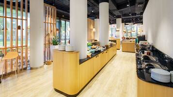 A modern cafe with a wooden counter, seating area, and large windows.