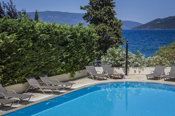 Piscine extérieure, parasols de plage, chaises longues