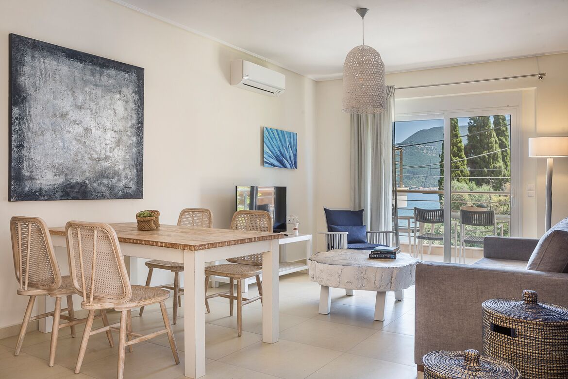 Una sala de estar moderna con comedor, un cuadro abstracto grande y vistas al exterior.