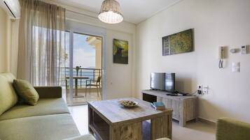 A modern living room with a sofa, a coffee table, a TV, and a balcony with a view.
