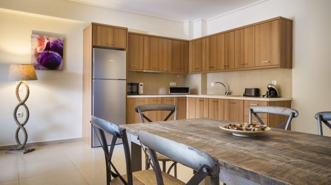 A modern kitchen with wooden cabinets, a stainless steel refrigerator, a microwave, and a coffee maker.