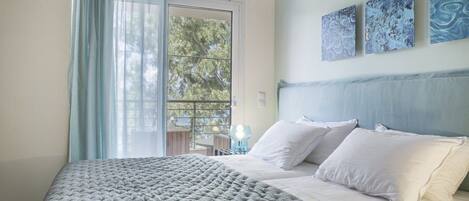 Une chambre à coucher comprenant un lit, une tête de lit, une table de chevet et une fenêtre avec des rideaux.